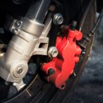 Gedetailleerde close-up van een rode motorfiets remklauw op een wiel